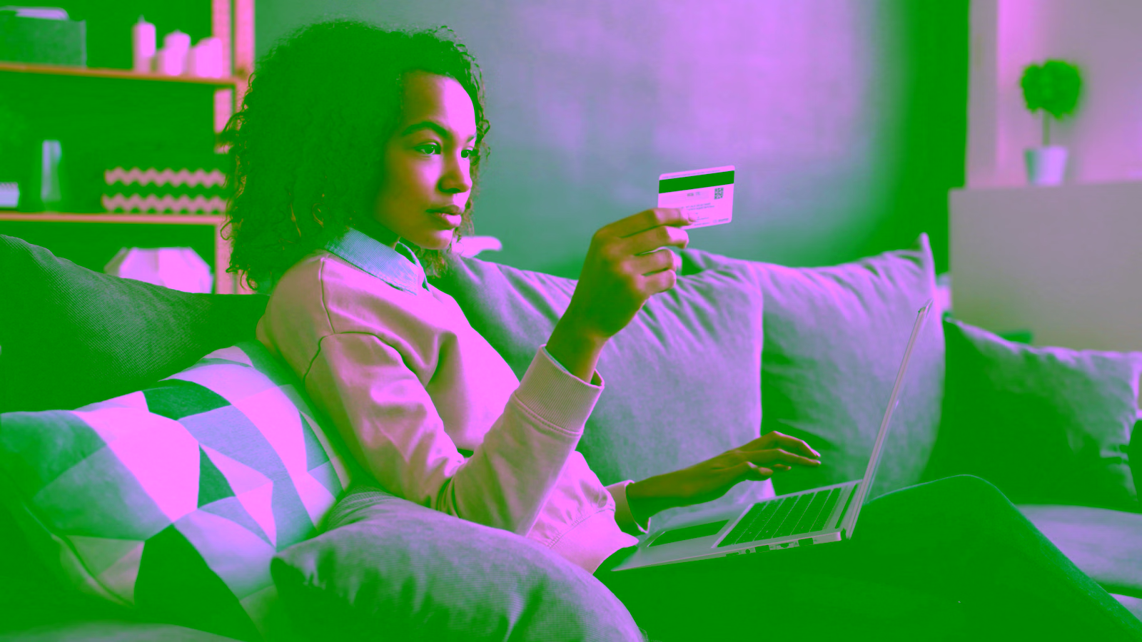 Woman holding a credit card while using laptop