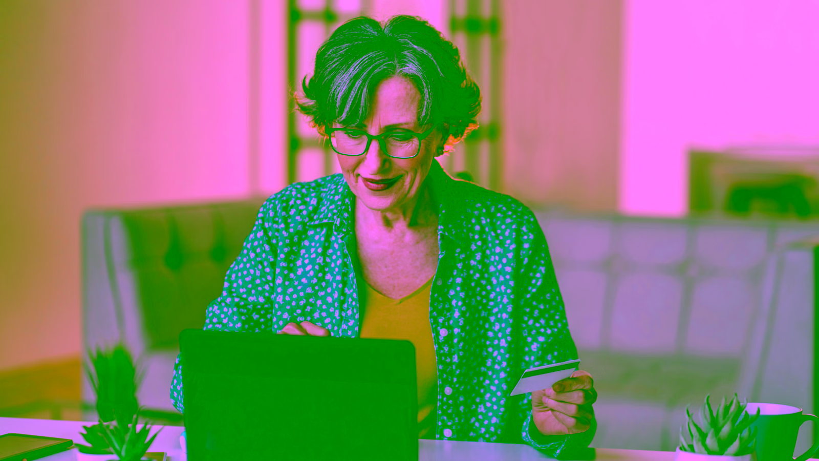 Woman reviewing credit cards on laptop at home