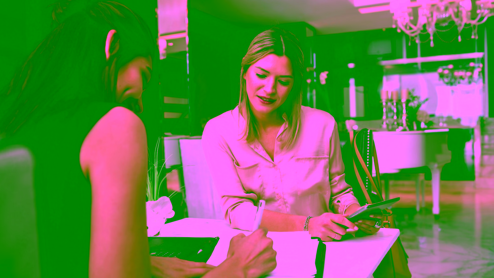 Two women booking hotels on laptop