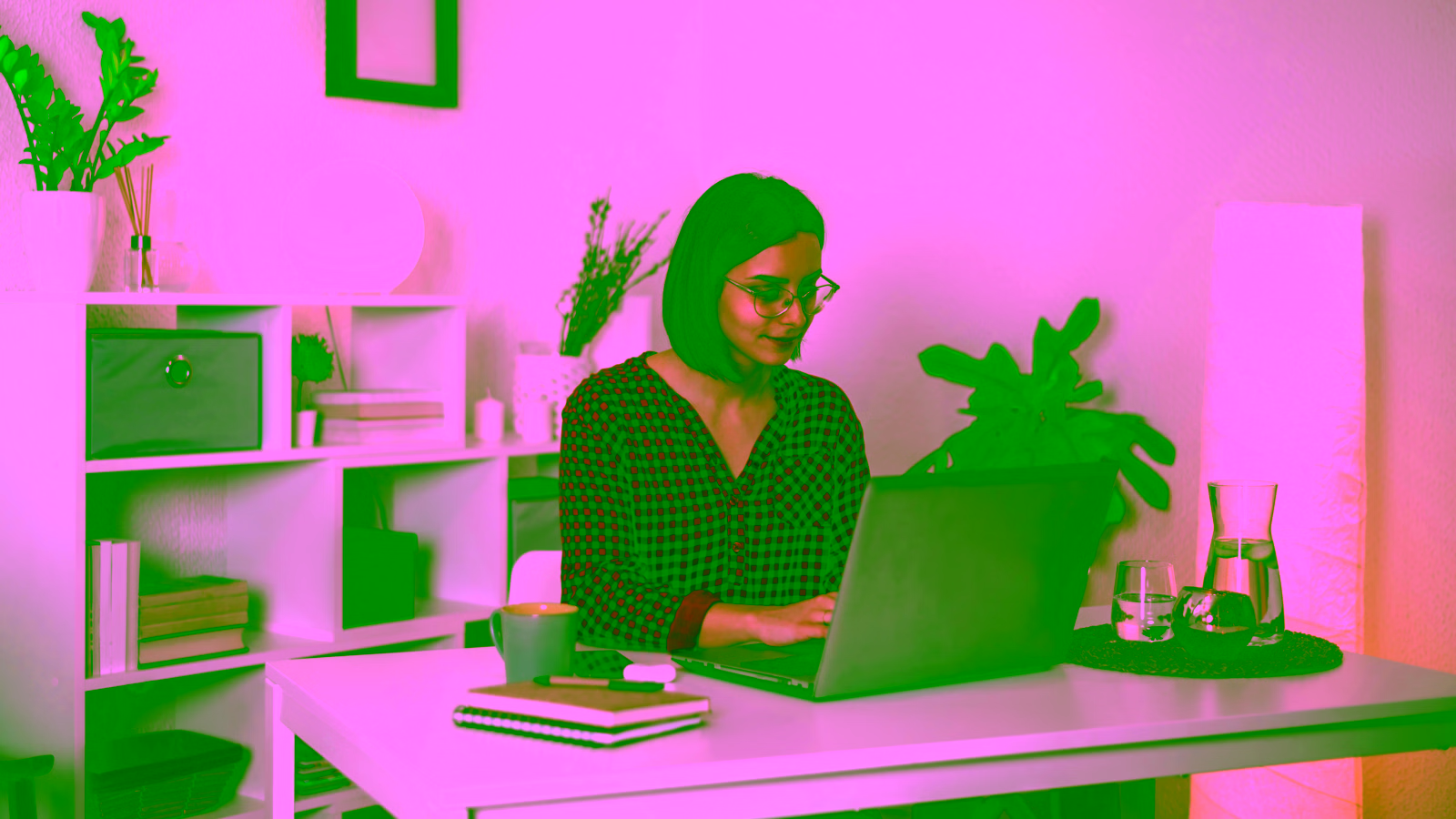 Woman working on laptop at home office desk