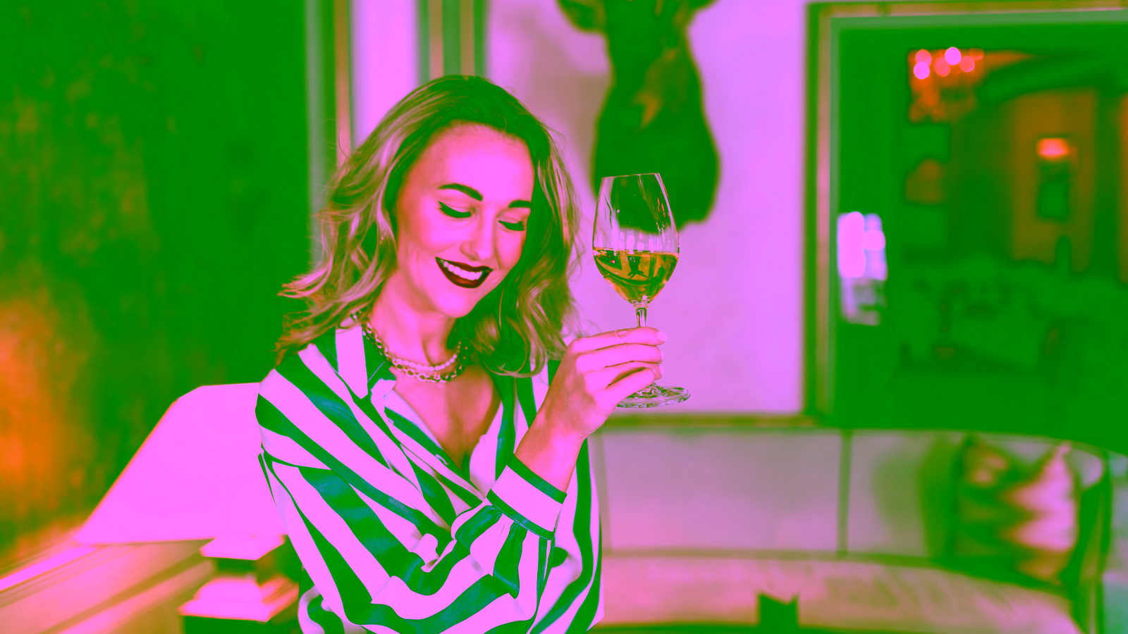 Woman enjoying white wine at upscale hotel lounge