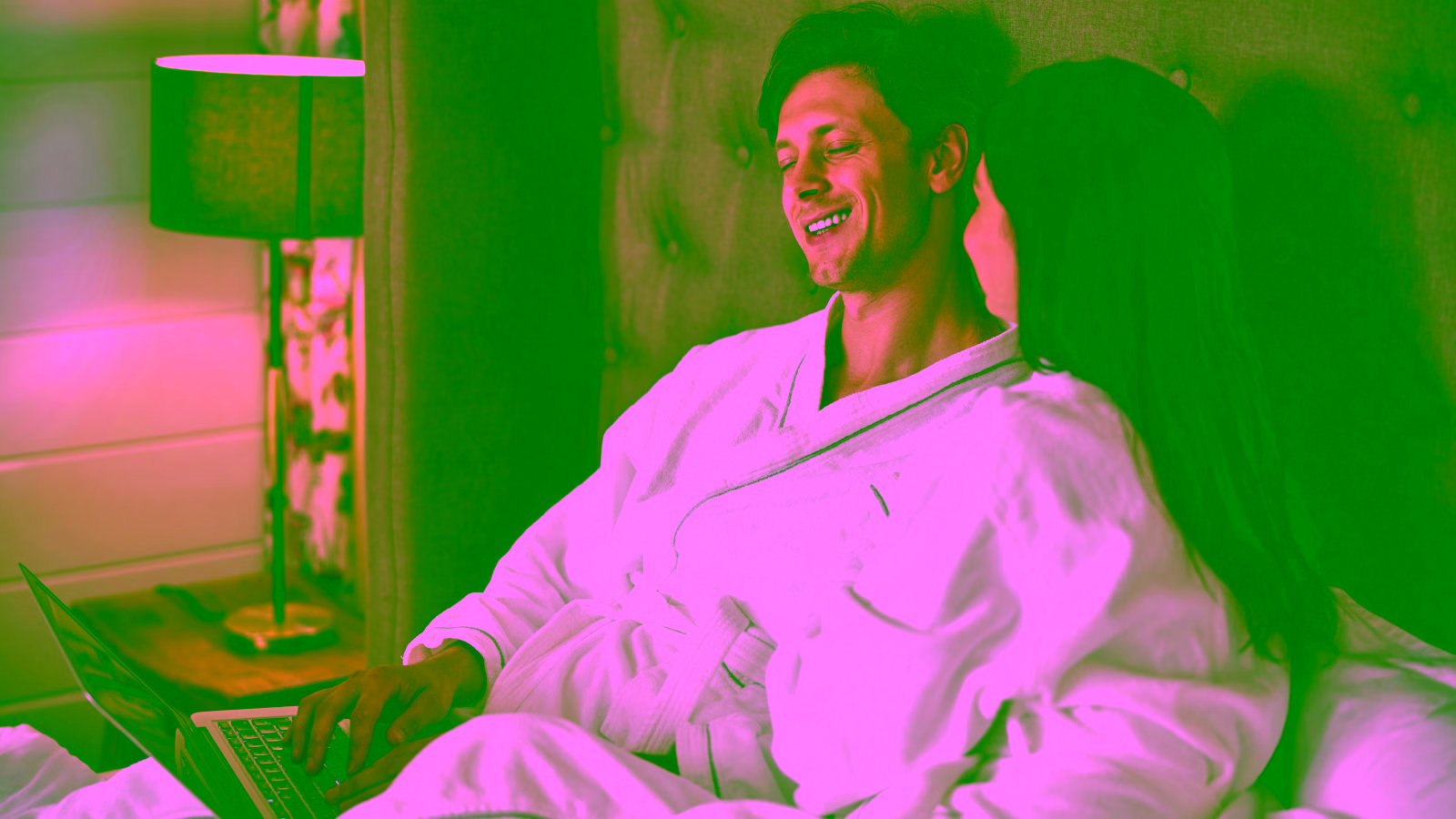 Couple relaxing in budget hotel room using laptop