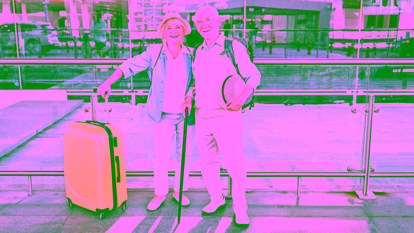 elderly travelers smiling with luggage