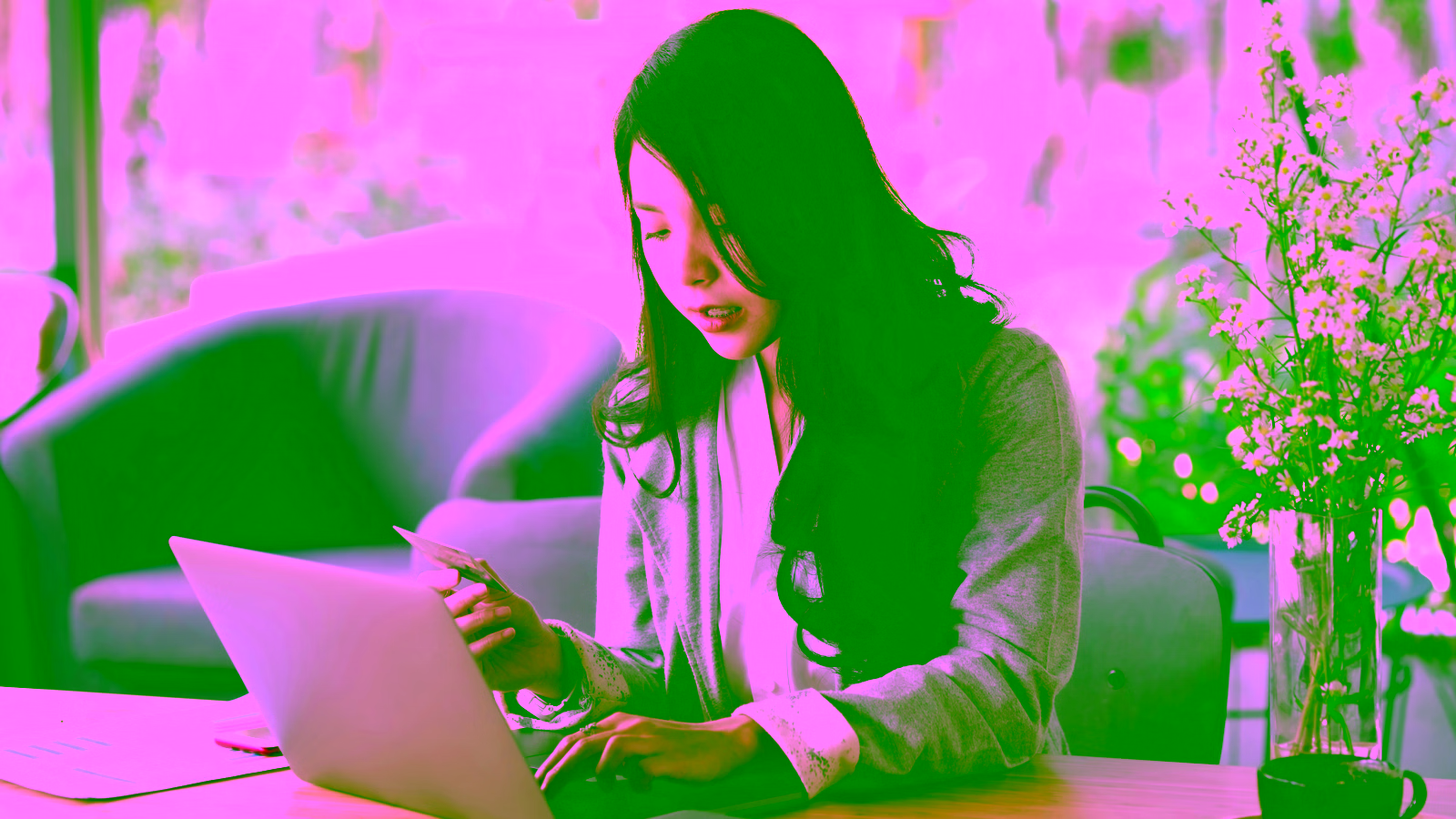Woman using laptop and holding credit card