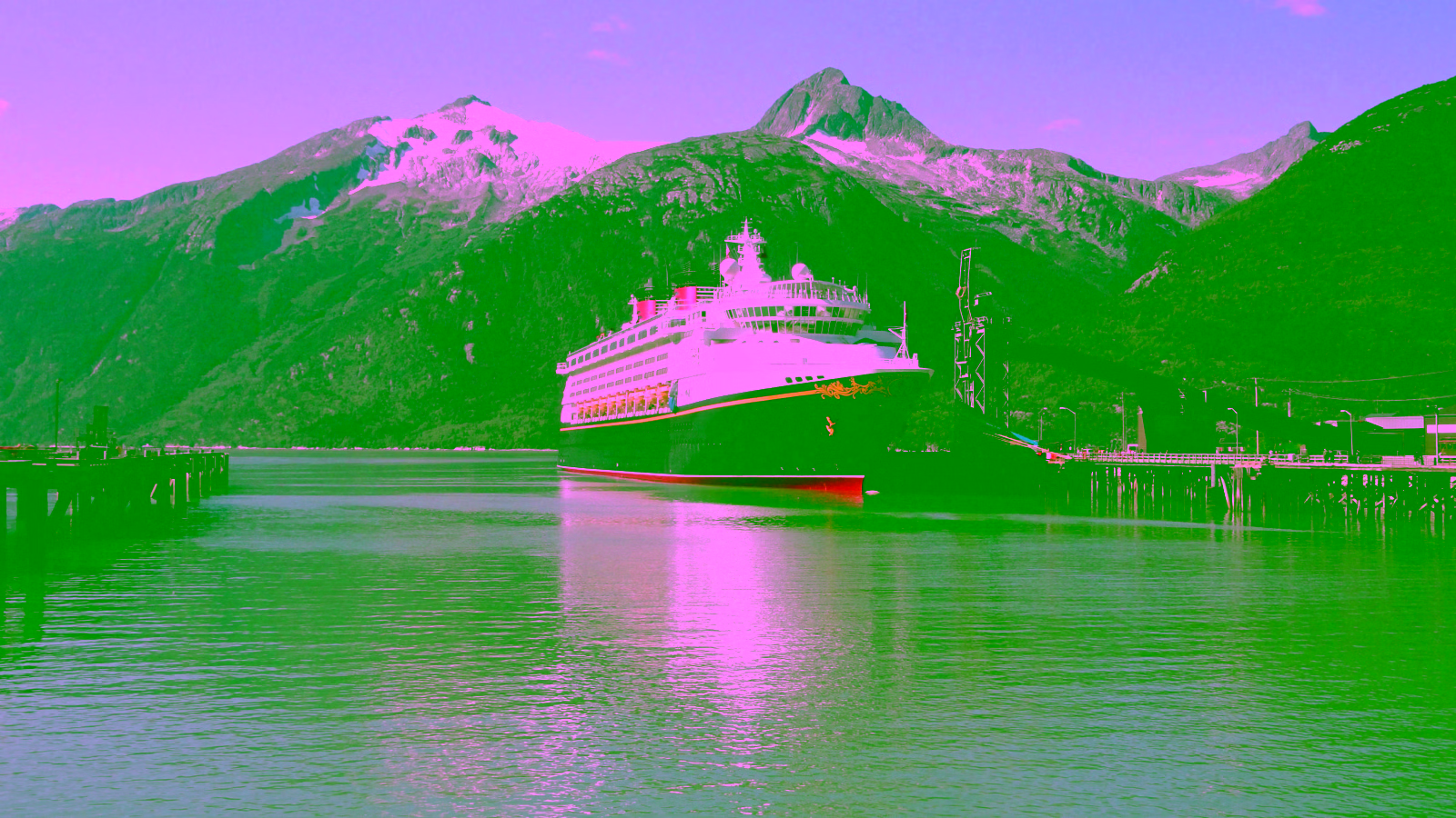 Cruise ship docked by mountain fjord