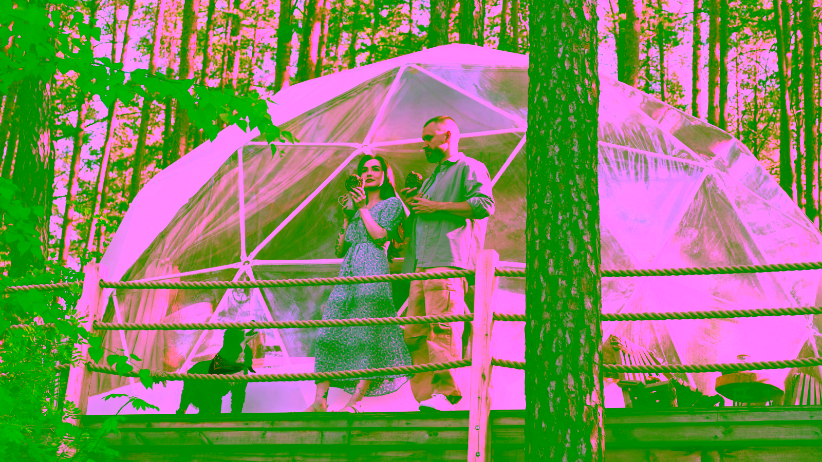 Couple at geodesic dome glamping site in forest