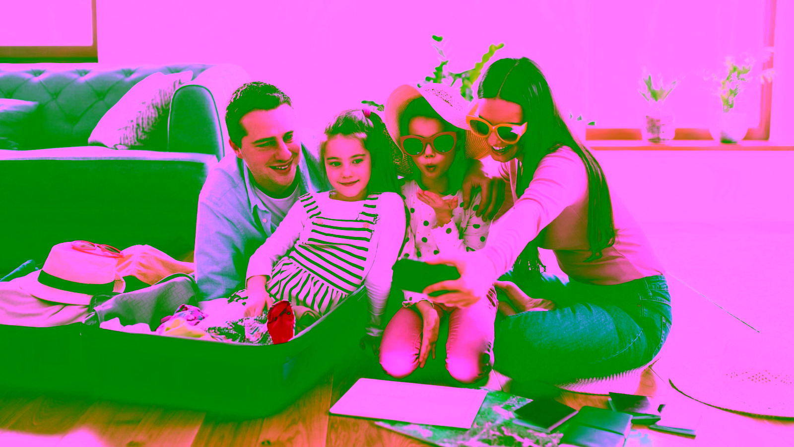Family taking a travel selfie while packing a suitcase