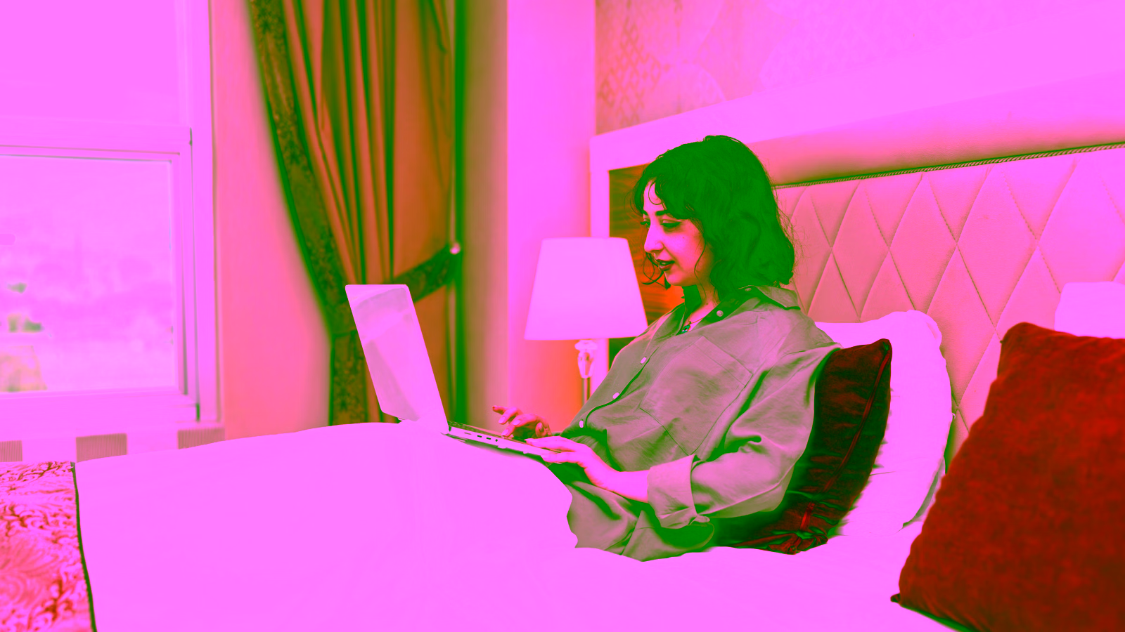 Woman using laptop in hotel room