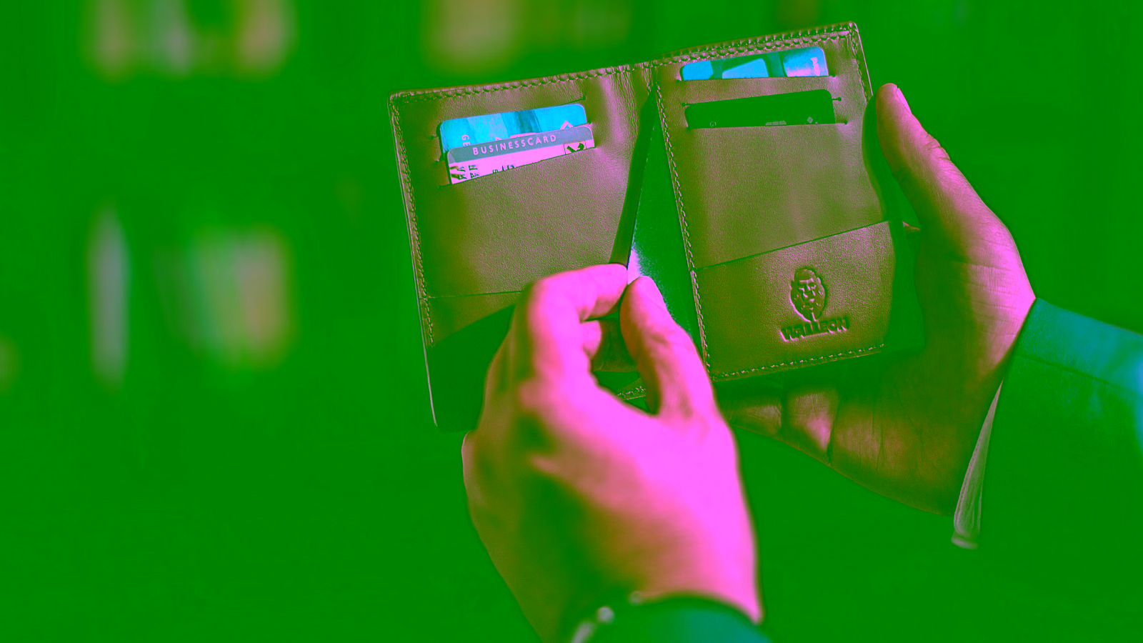 Person holding a leather wallet with credit cards.