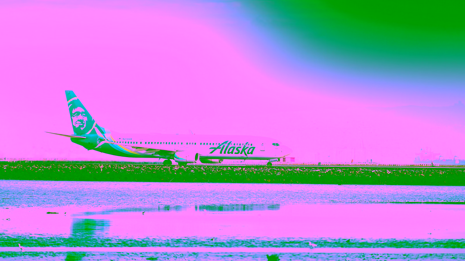 Alaska Airlines plane on runway near water