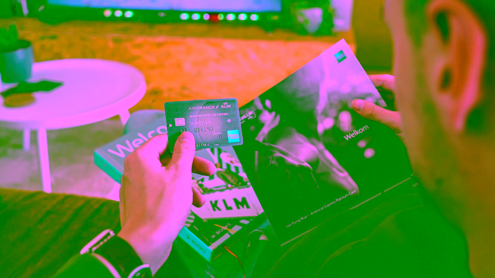 Person holding new Amex card and welcome materials