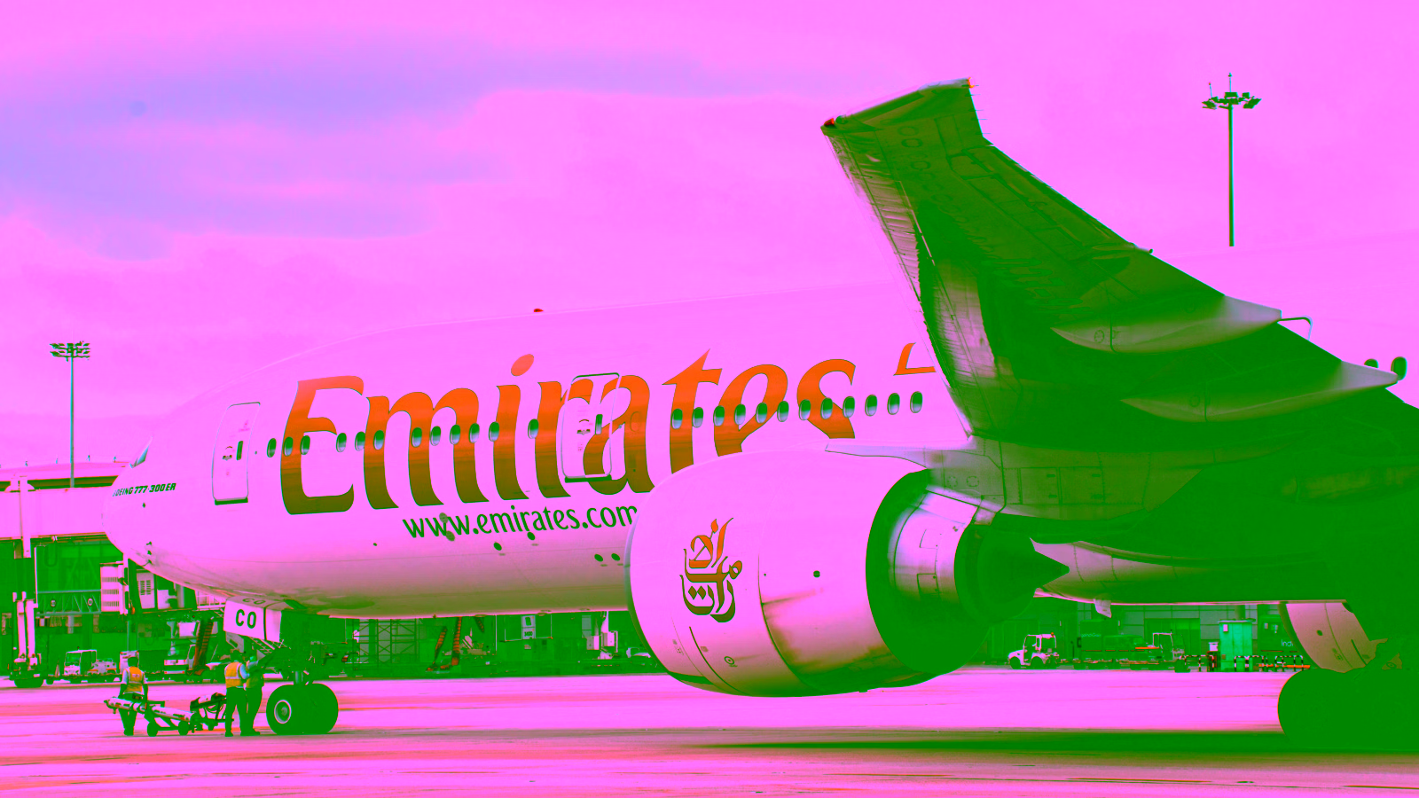 Emirates plane at the airport under cloudy skies