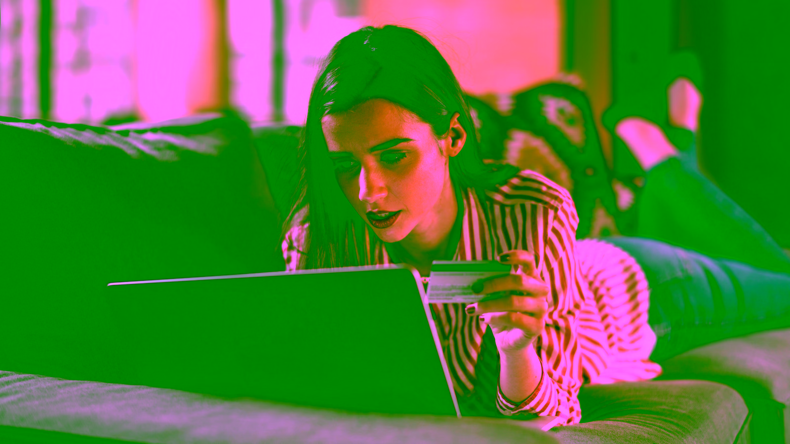 Woman shopping online with credit card on laptop