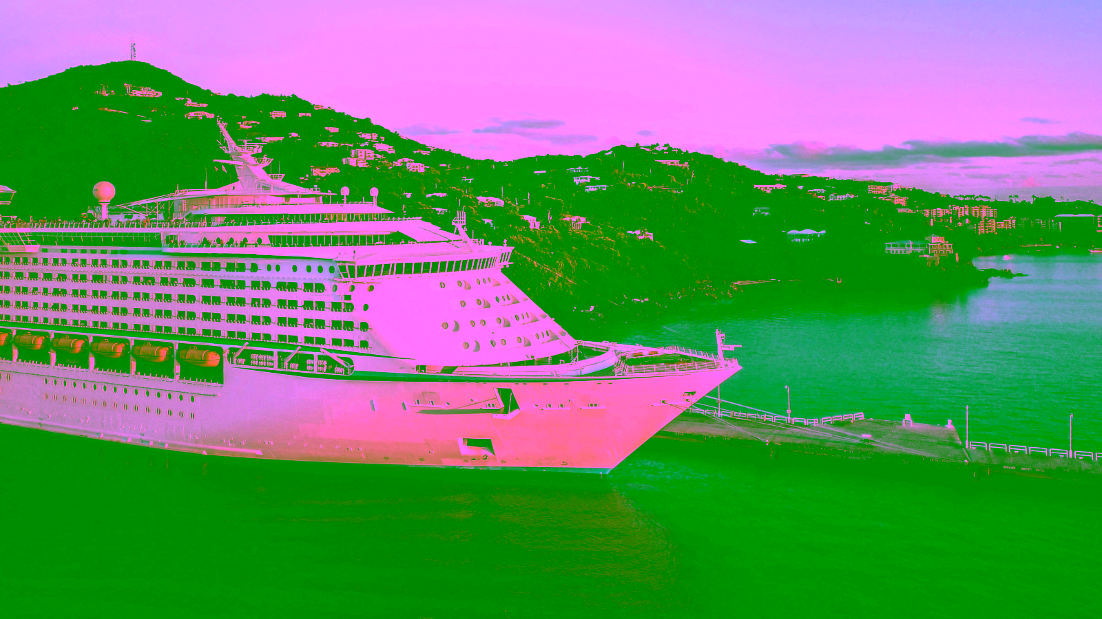 Large cruise ship docked at tropical island port
