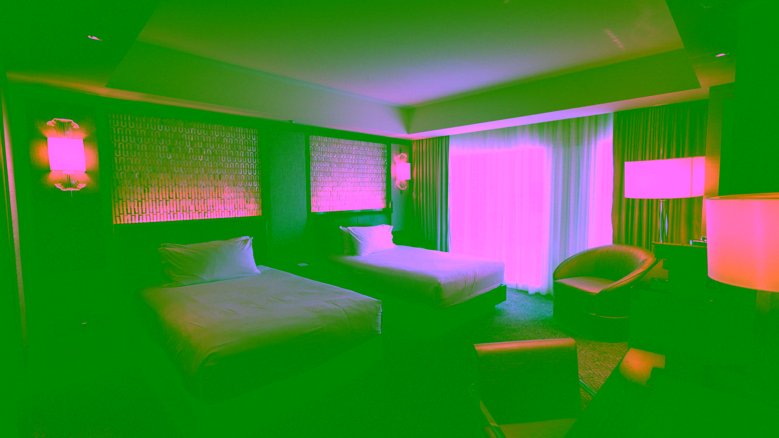 Modern hotel room with twin beds and a large window.