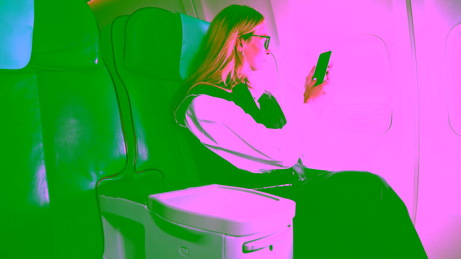 Woman using phone on airplane seat