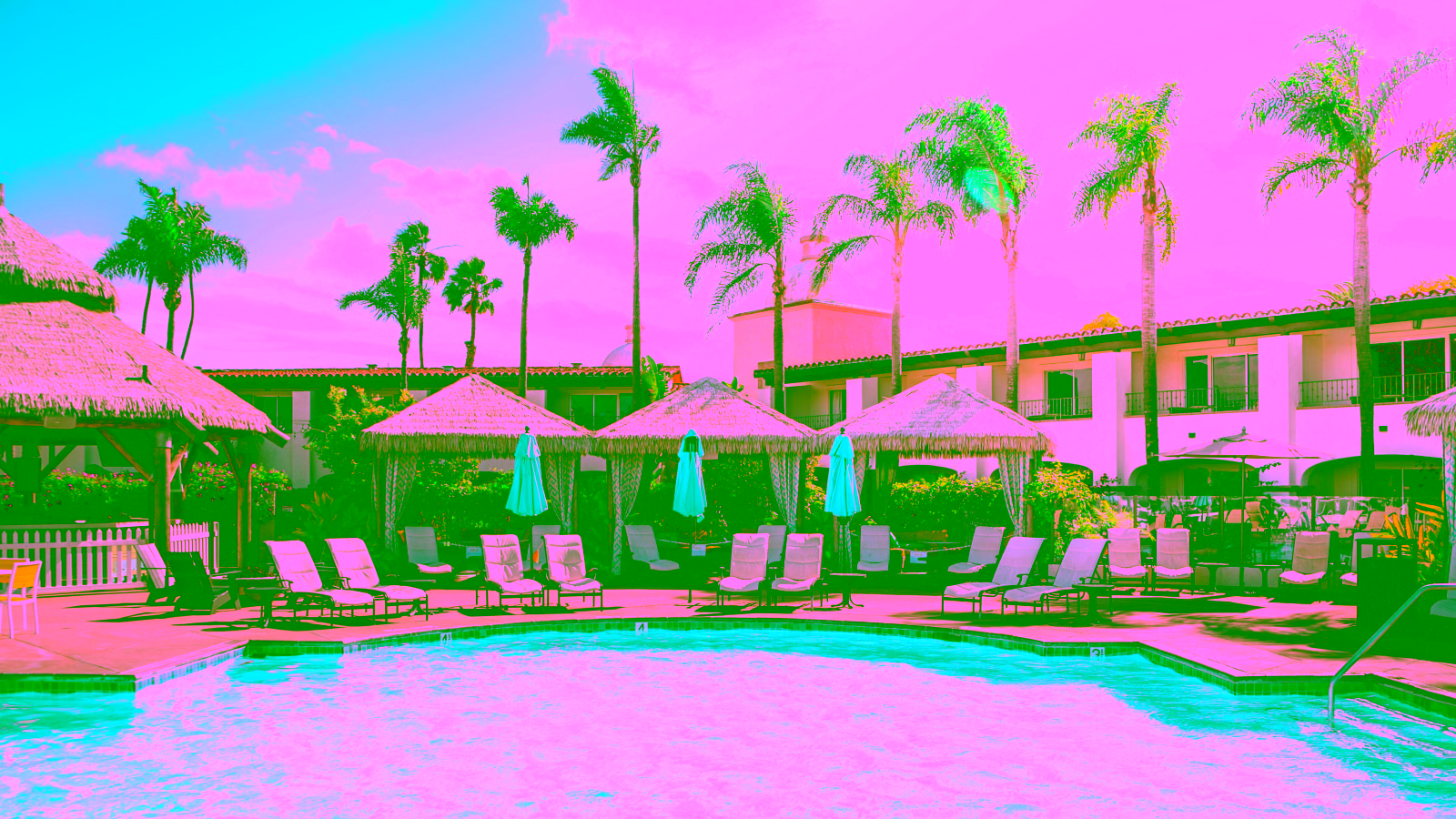 Resort pool with palm trees and cabanas
