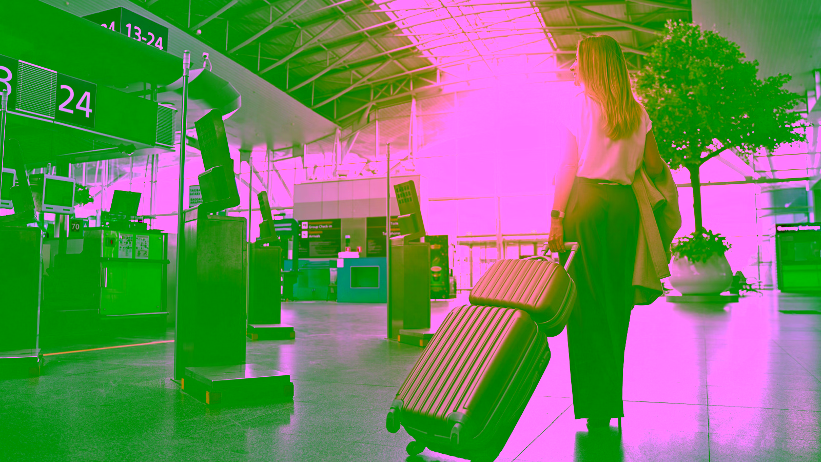 Woman rolling luggage through airport terminal