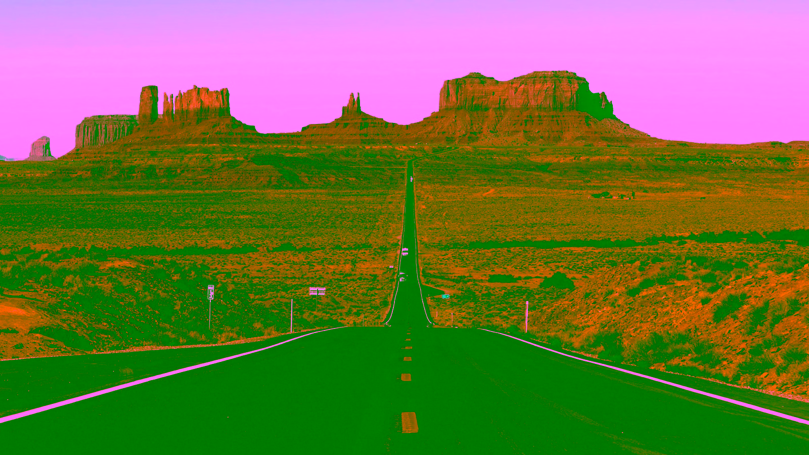 Desert highway leading to Monument Valley formations