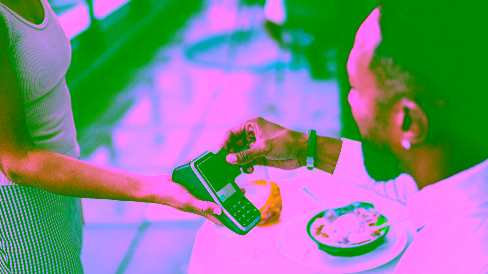 Customer making a contactless card payment at a restaurant.