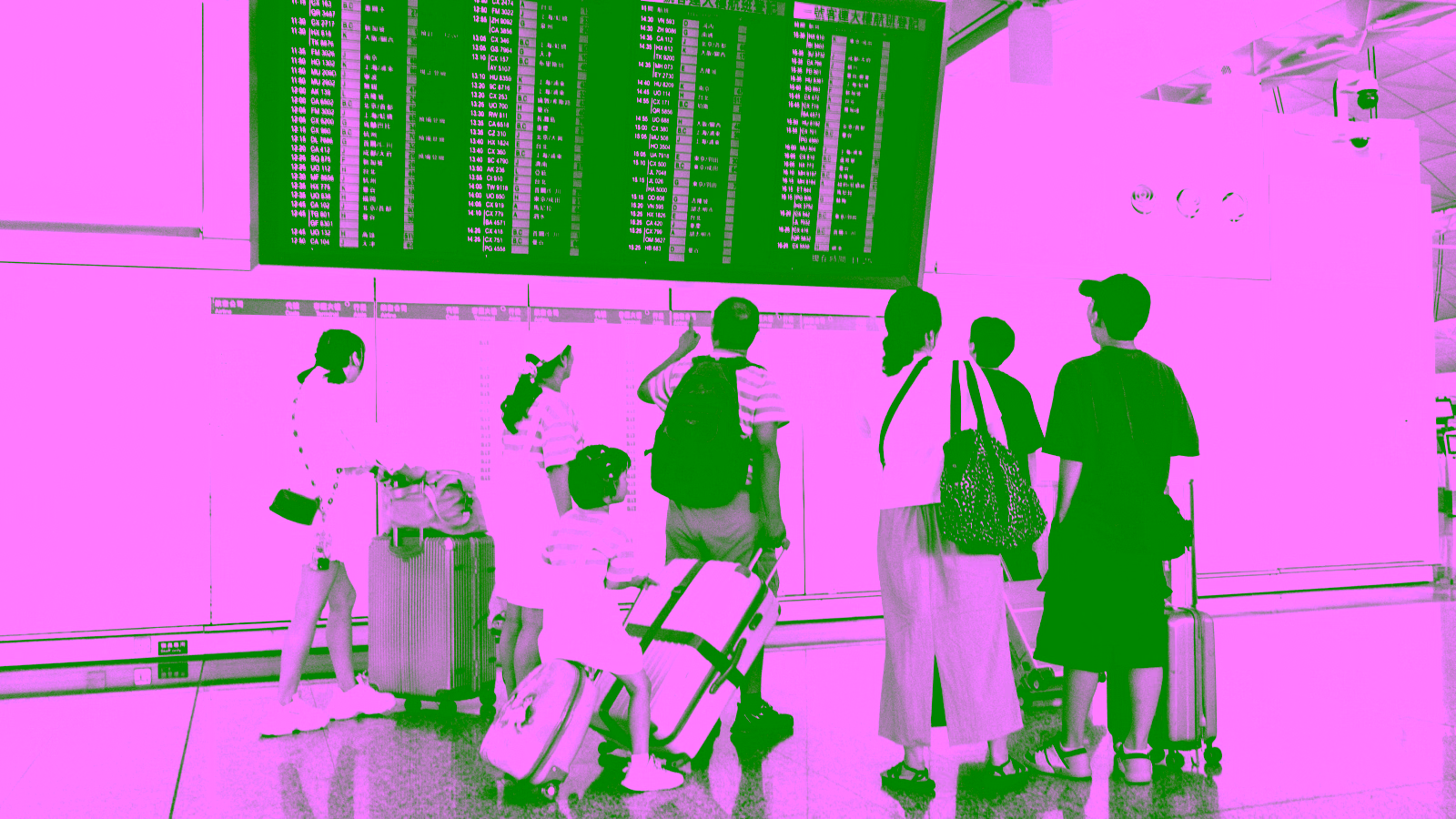 Travelers checking airport departure board