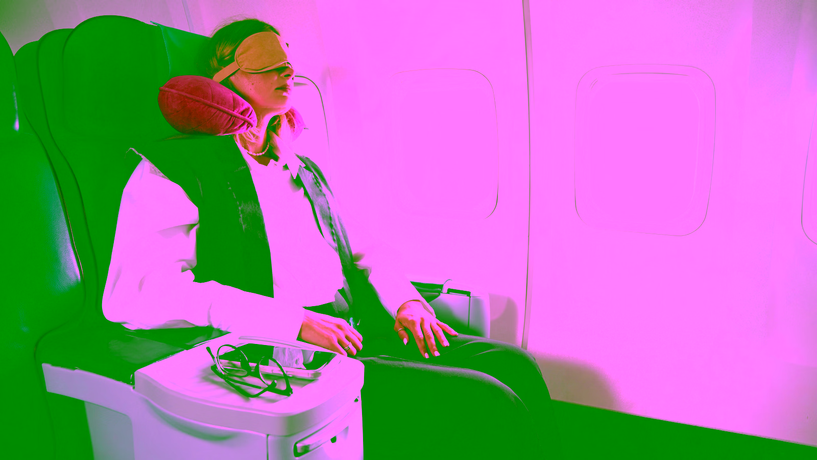Passenger resting with a travel neck pillow on a plane