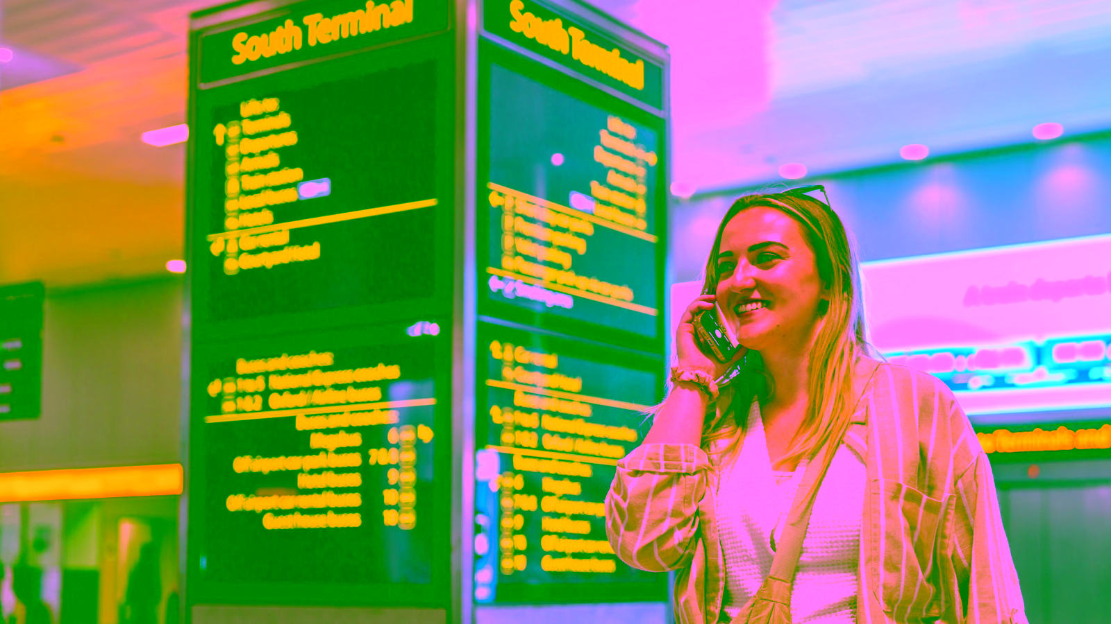 Traveler at airport departure board on phone
