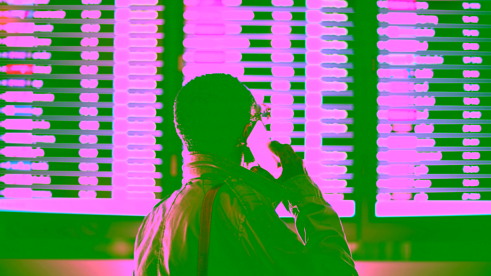Traveler checking flight departure board while on the phone