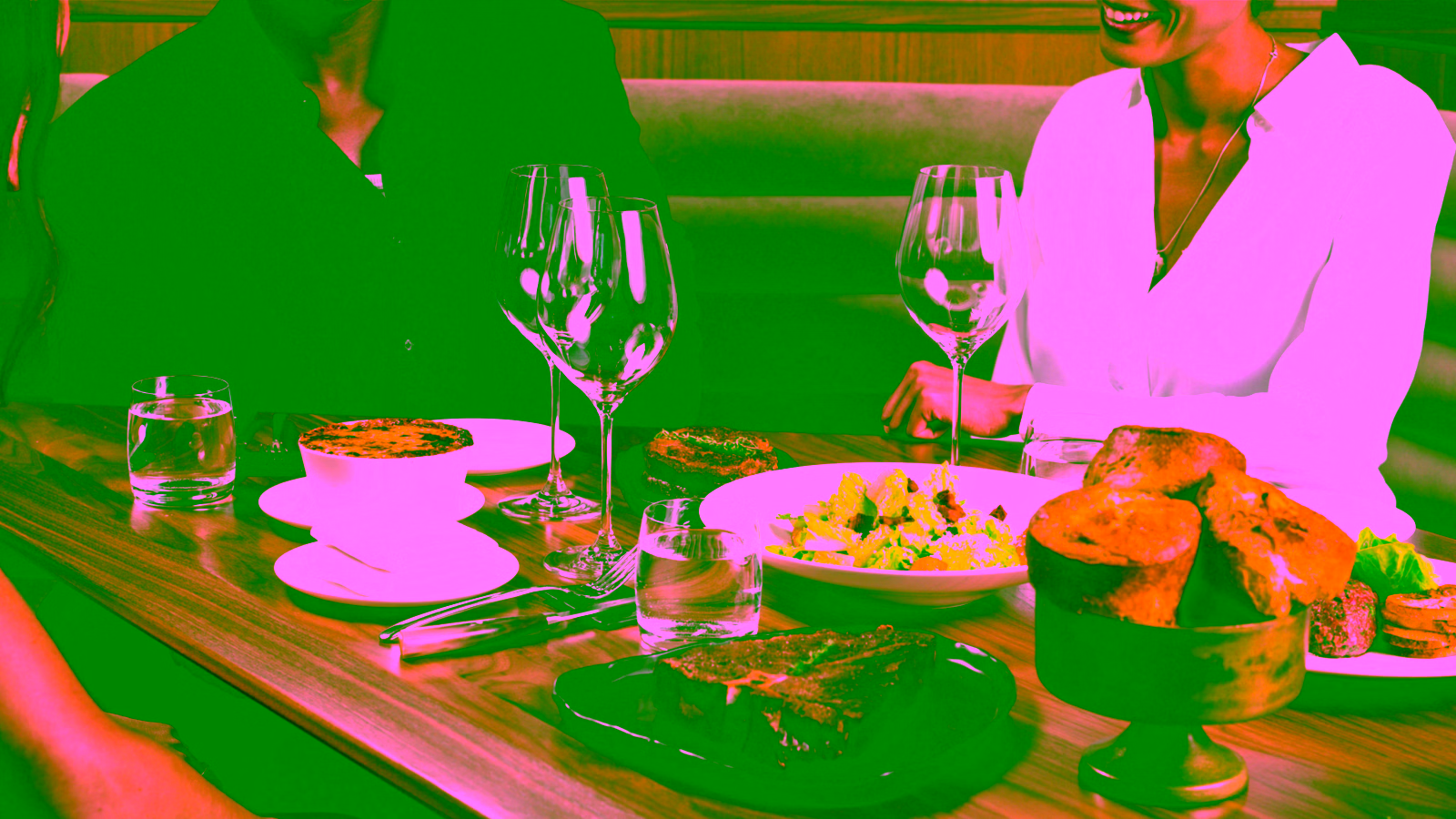 People dining at a restaurant with steak and side dishes