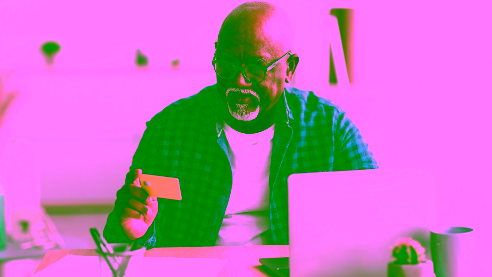 Man holding a credit card while using a laptop