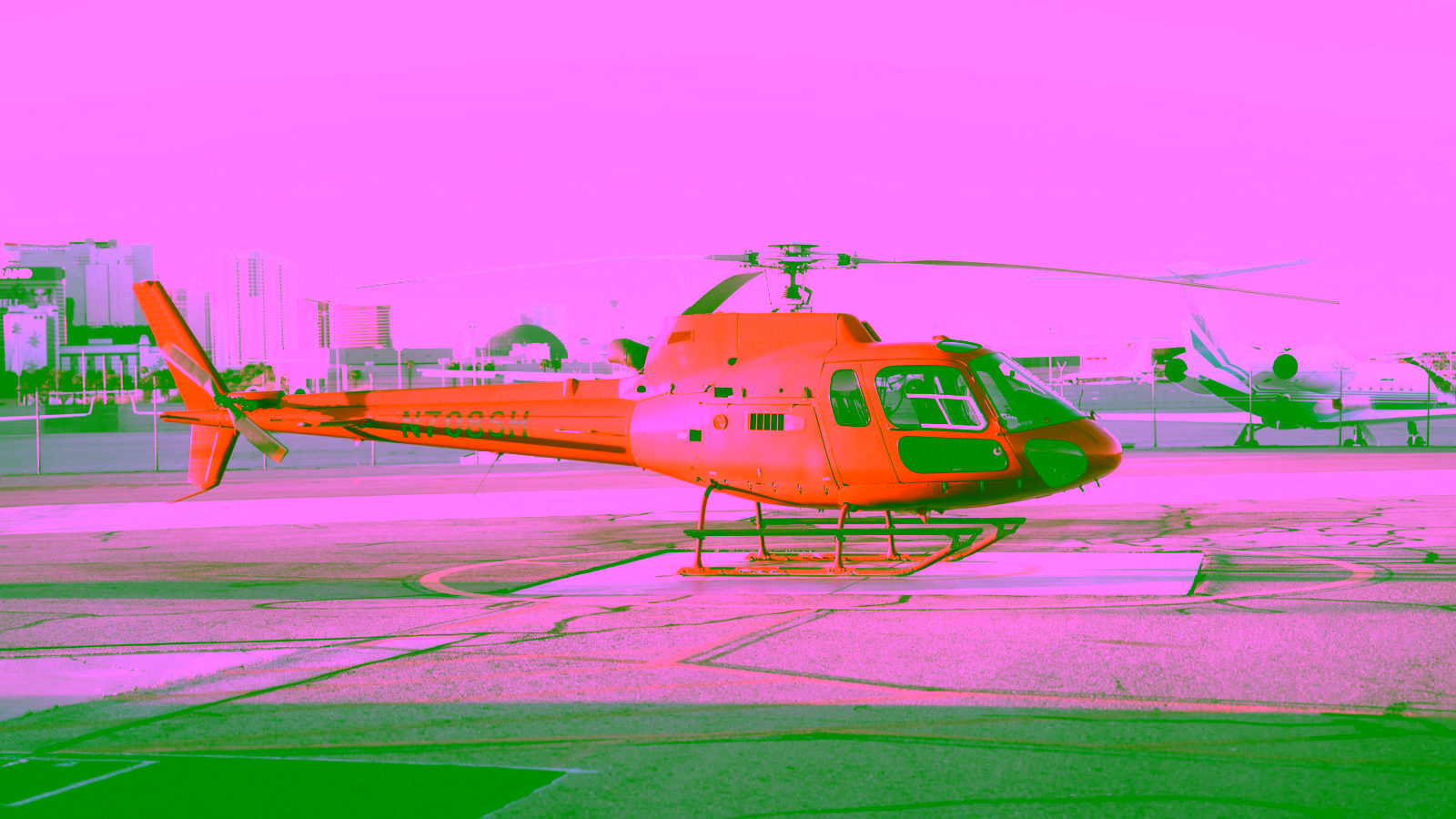Orange helicopter on an airport runway
