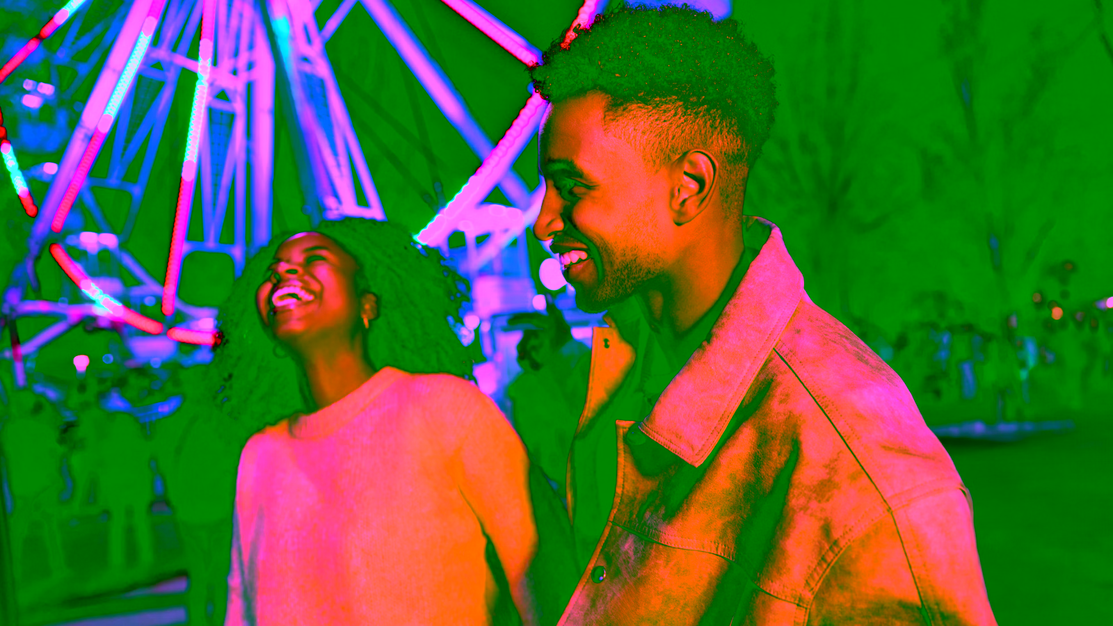 People enjoying a fairground at night