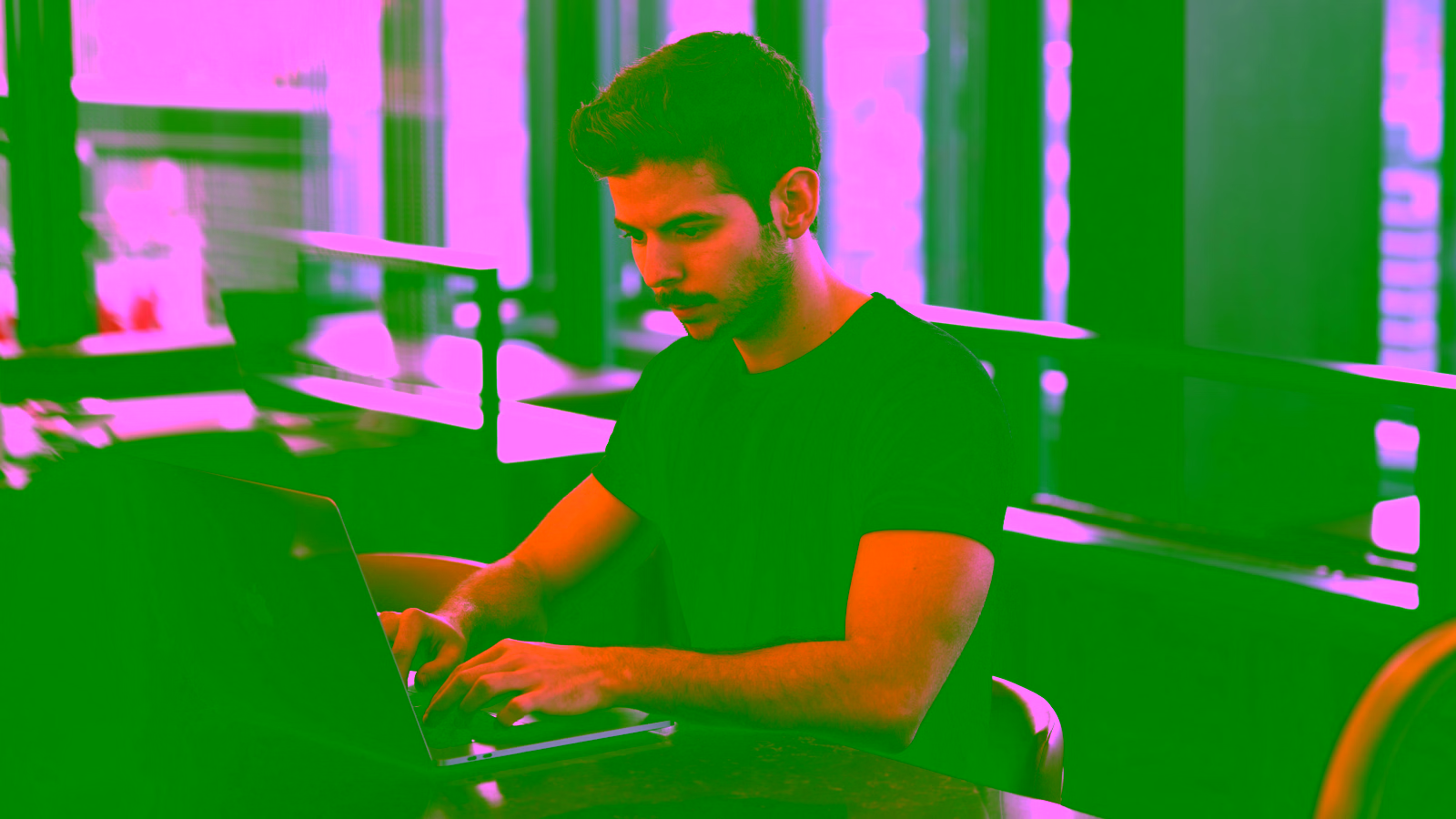 Man working on a laptop in a cafe.