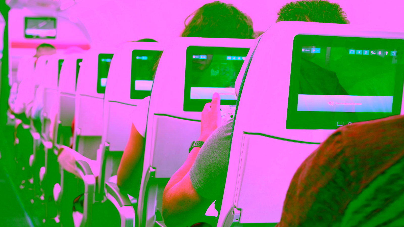 Passengers using entertainment screens on an airplane