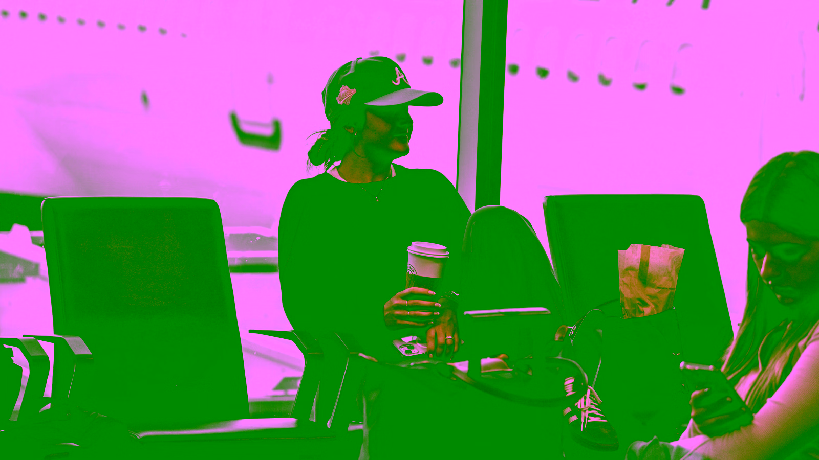 Woman waiting at an airport gate with coffee