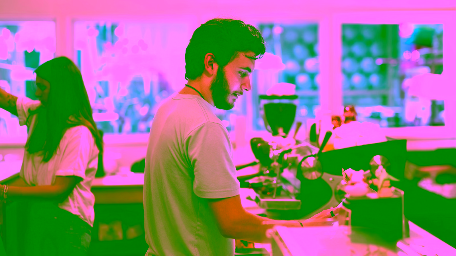 Man preparing coffee at a café counter