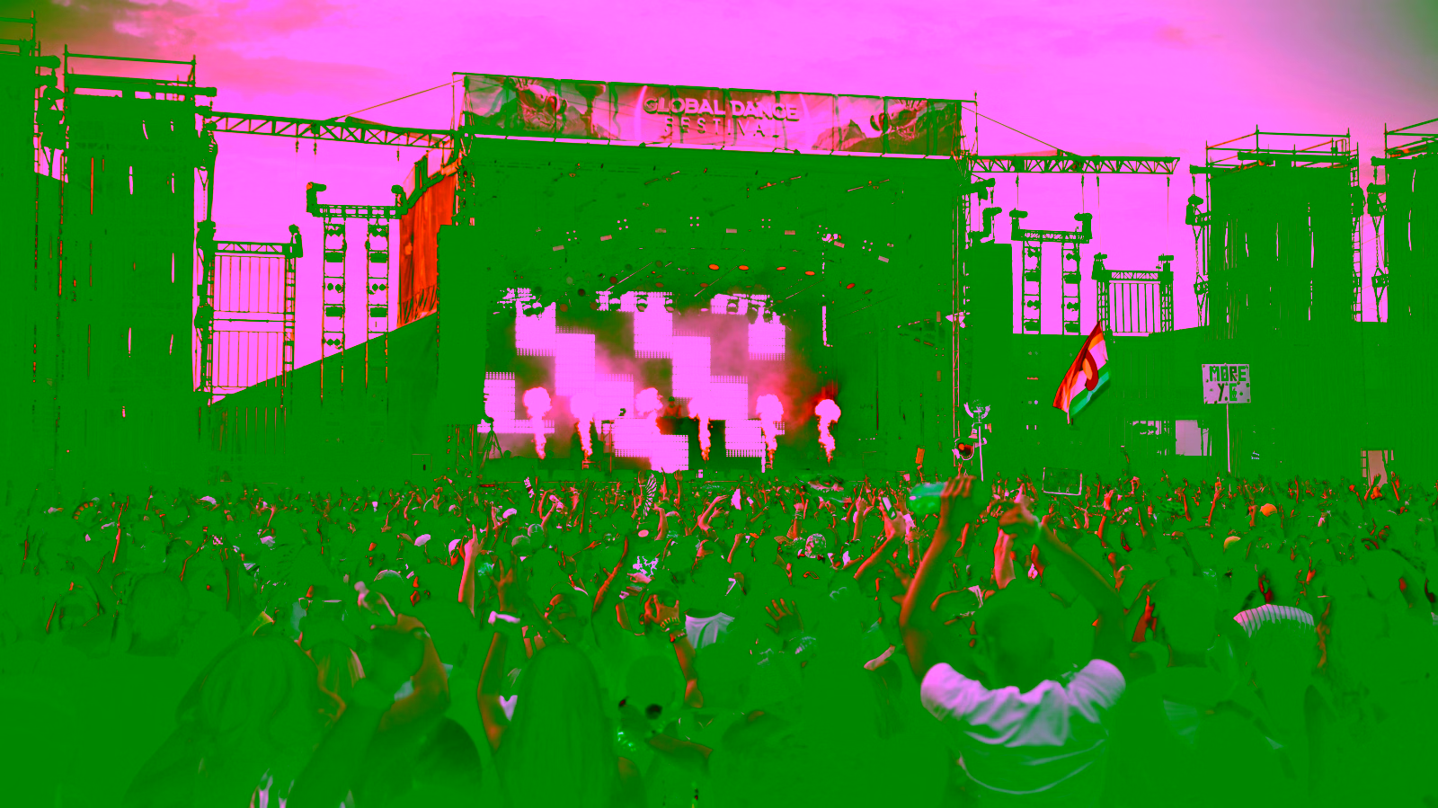 Crowd at a live music festival with stage lights and fireworks