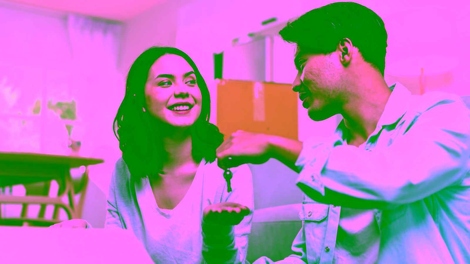 Couple exchanging house keys while moving into a new home