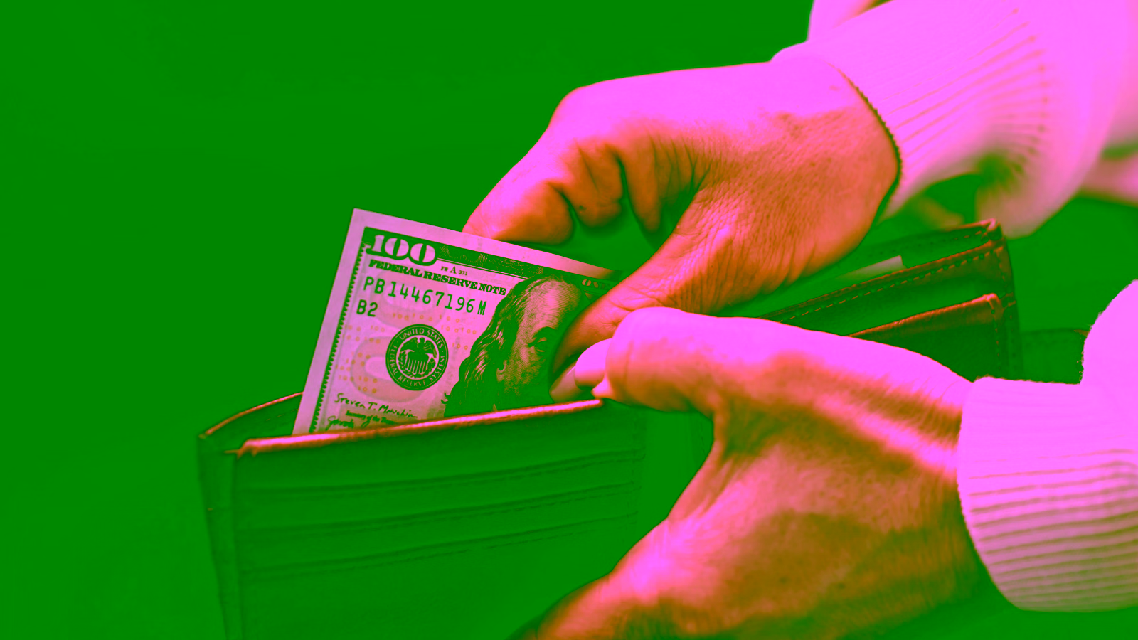 Hands putting cash into a leather wallet