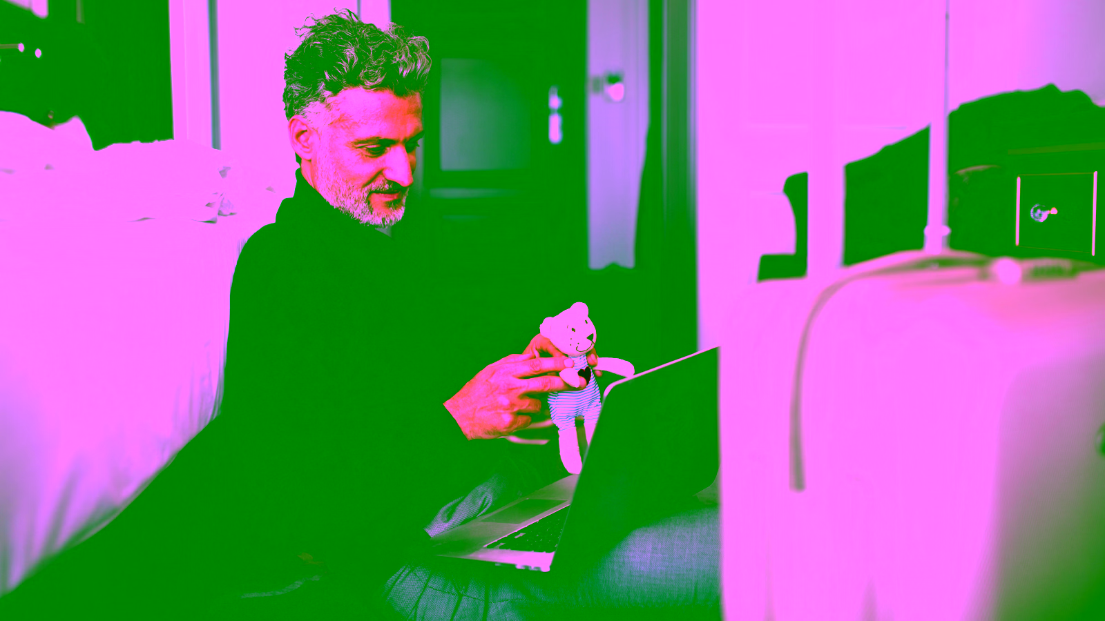 Man booking travel on laptop in hotel room