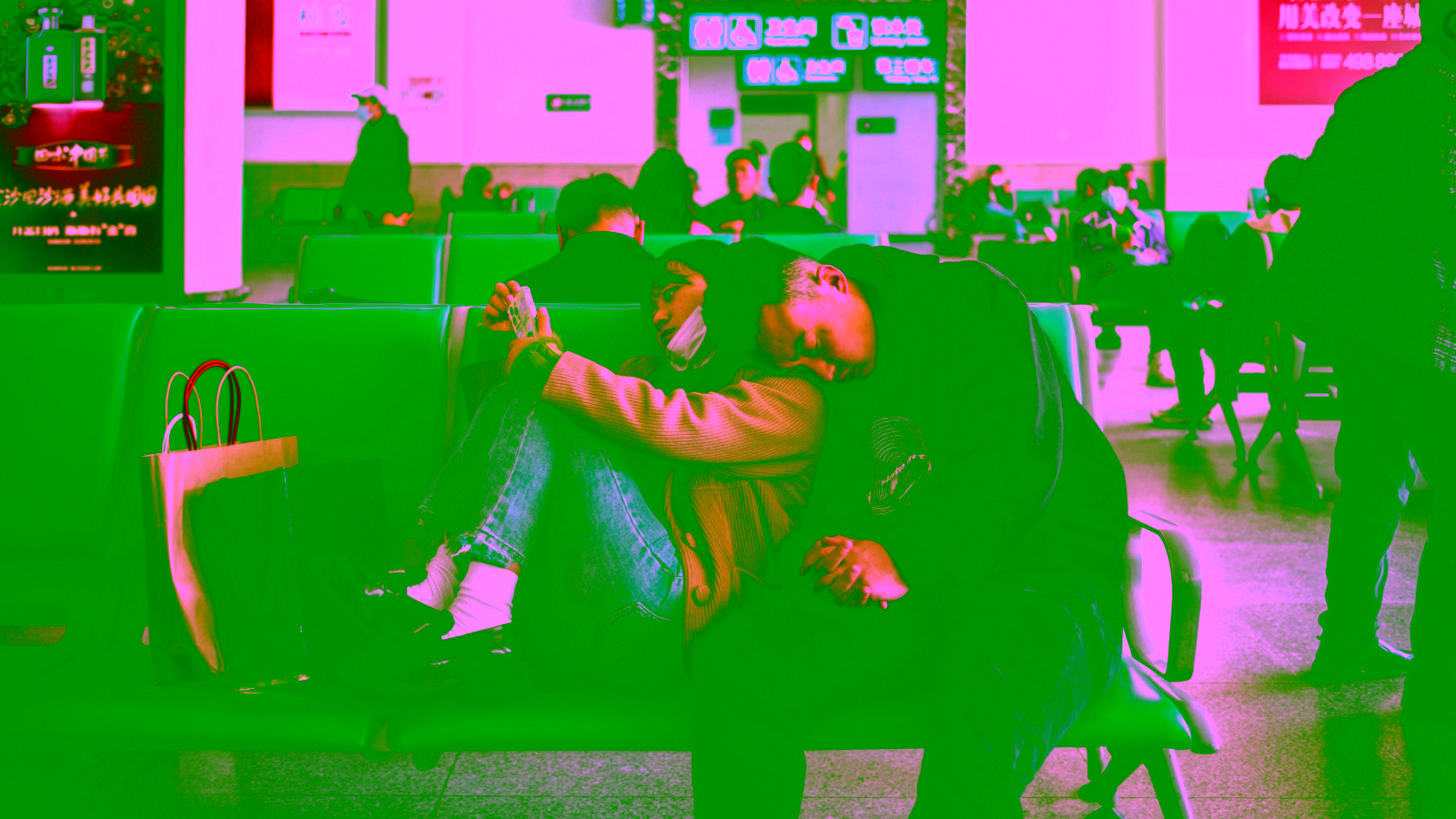 Couple resting together in an airport terminal waiting area