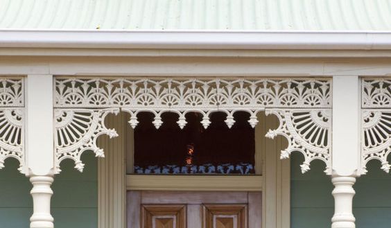 This may contain: the front porch of a house with an ornate design on it's side door