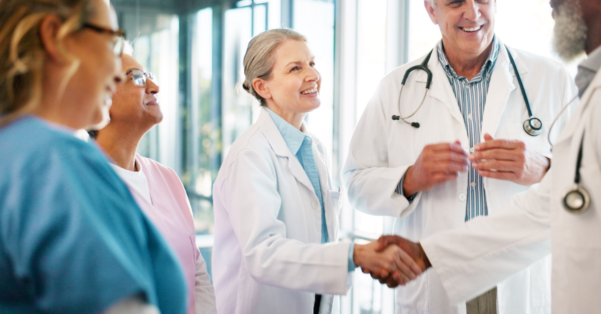 A group of life science professionals shaking hands and smiling