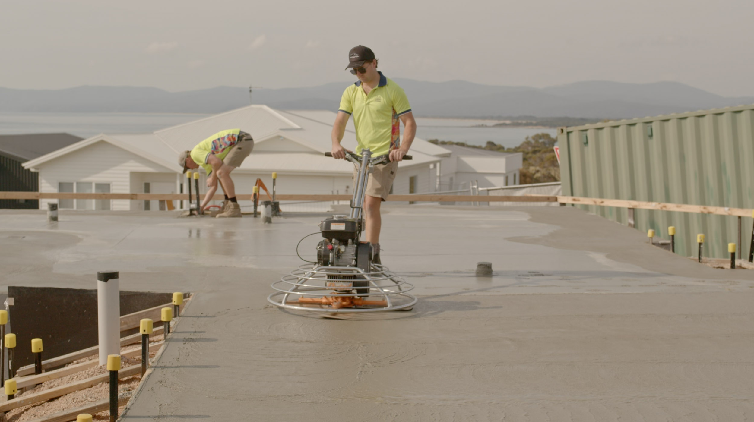 A person smoothing the concrete with a power trowel.