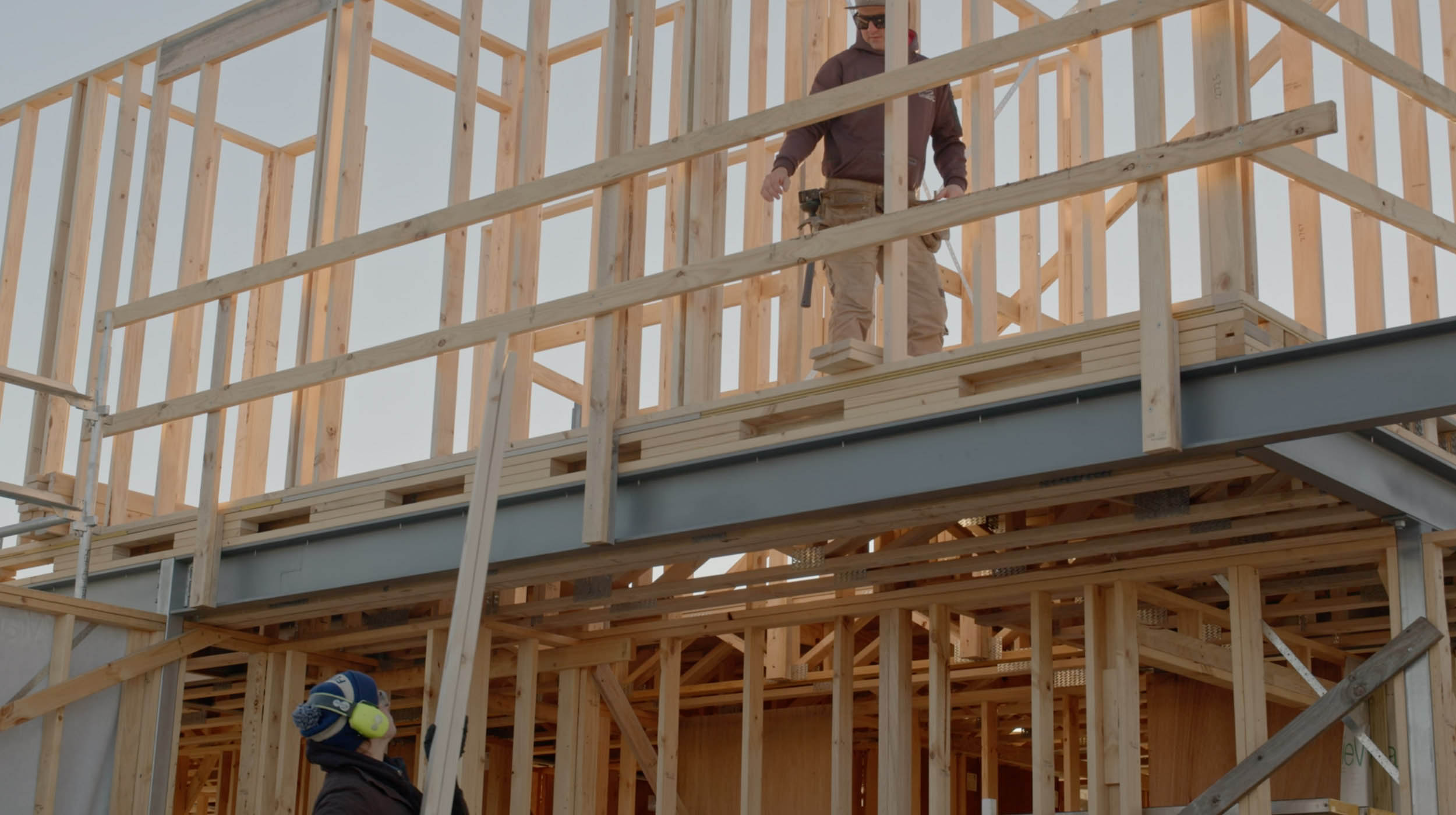House frame with a person standing on the top floor.