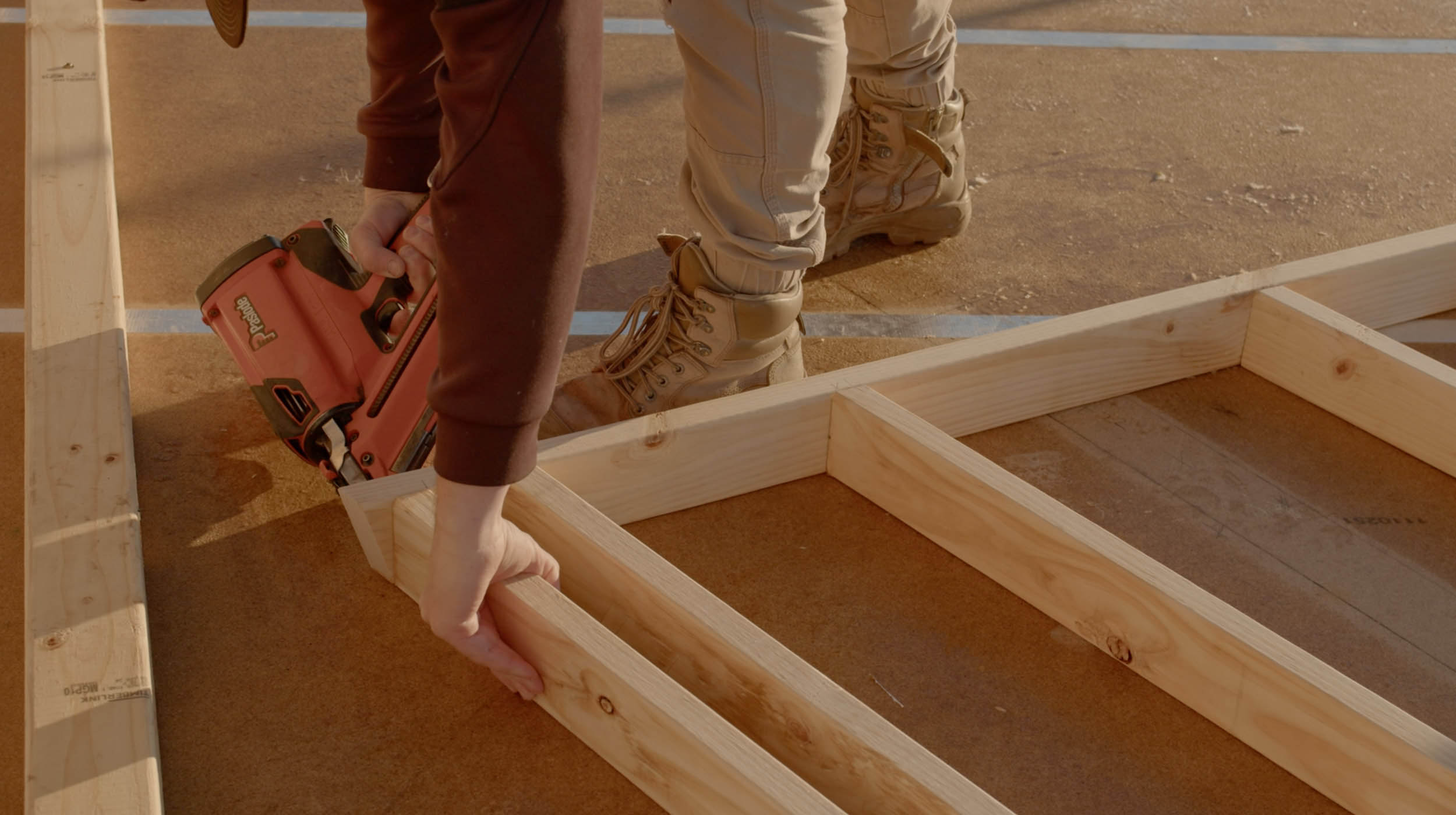 House frame with a person fitting nails to it.