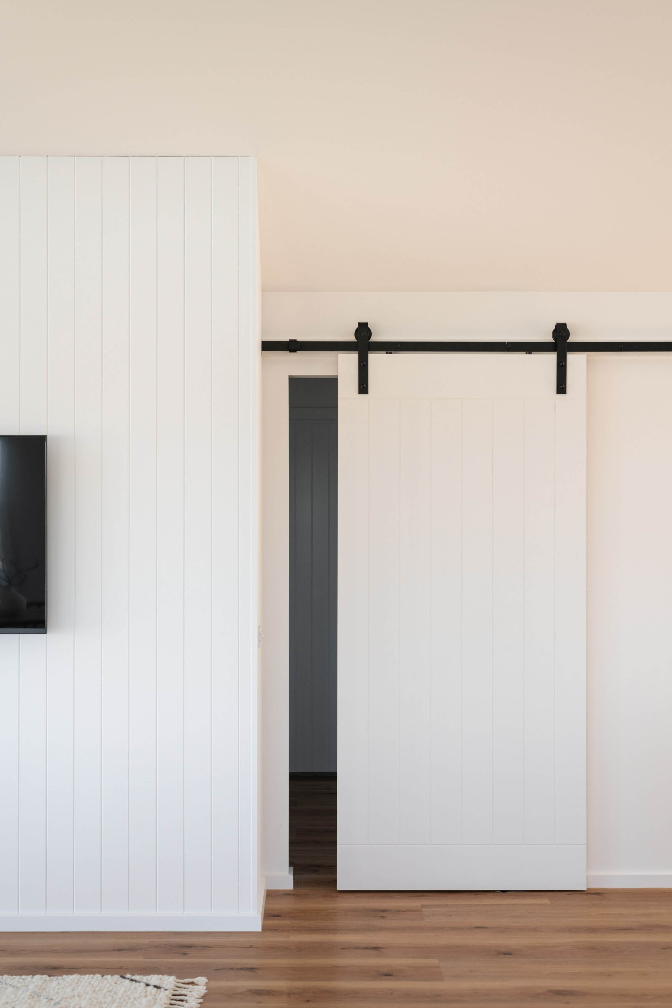 A large white sliding door sitting on a black hinge.