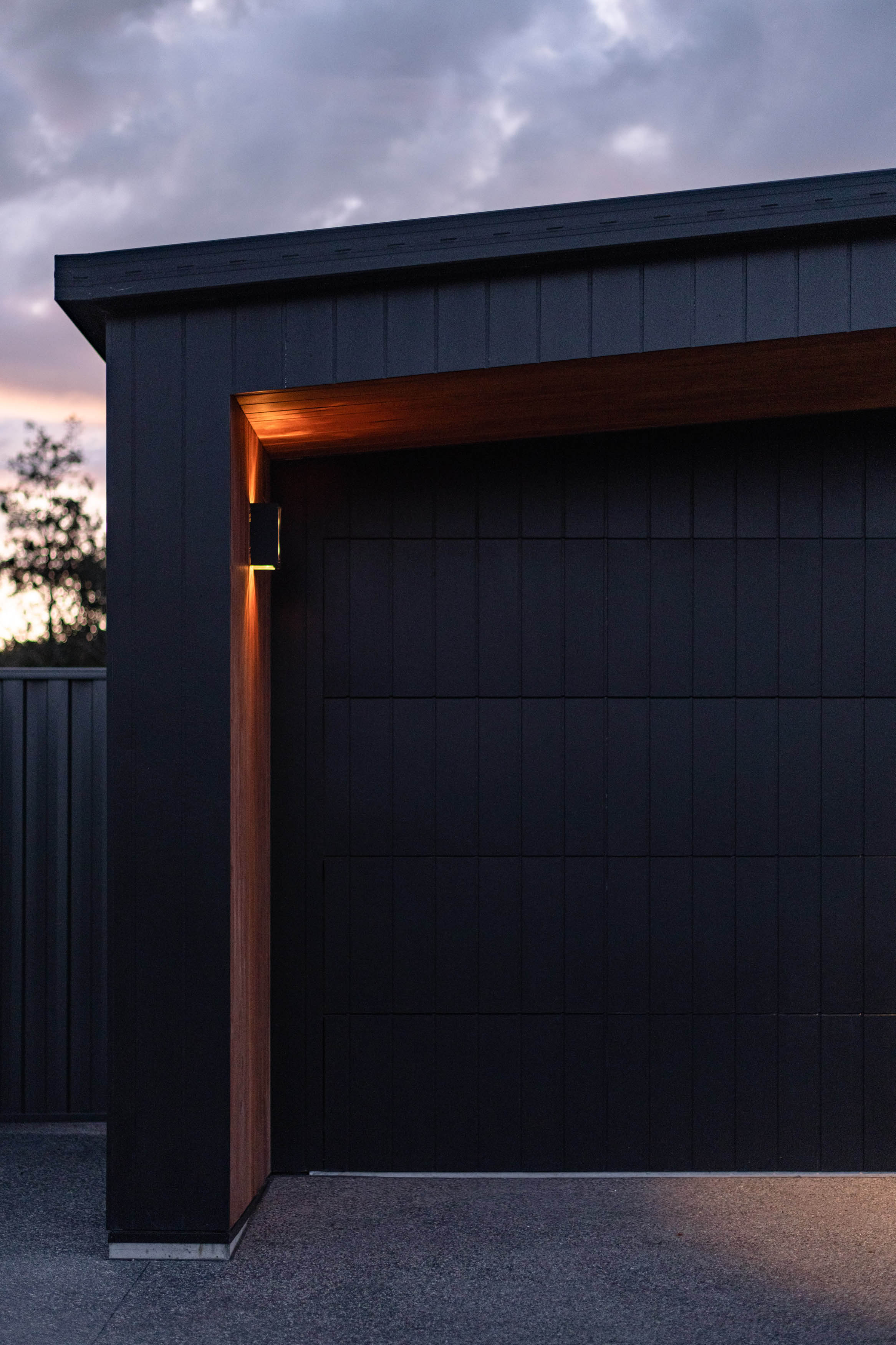 A Twilight sky with a white house with a black roof.