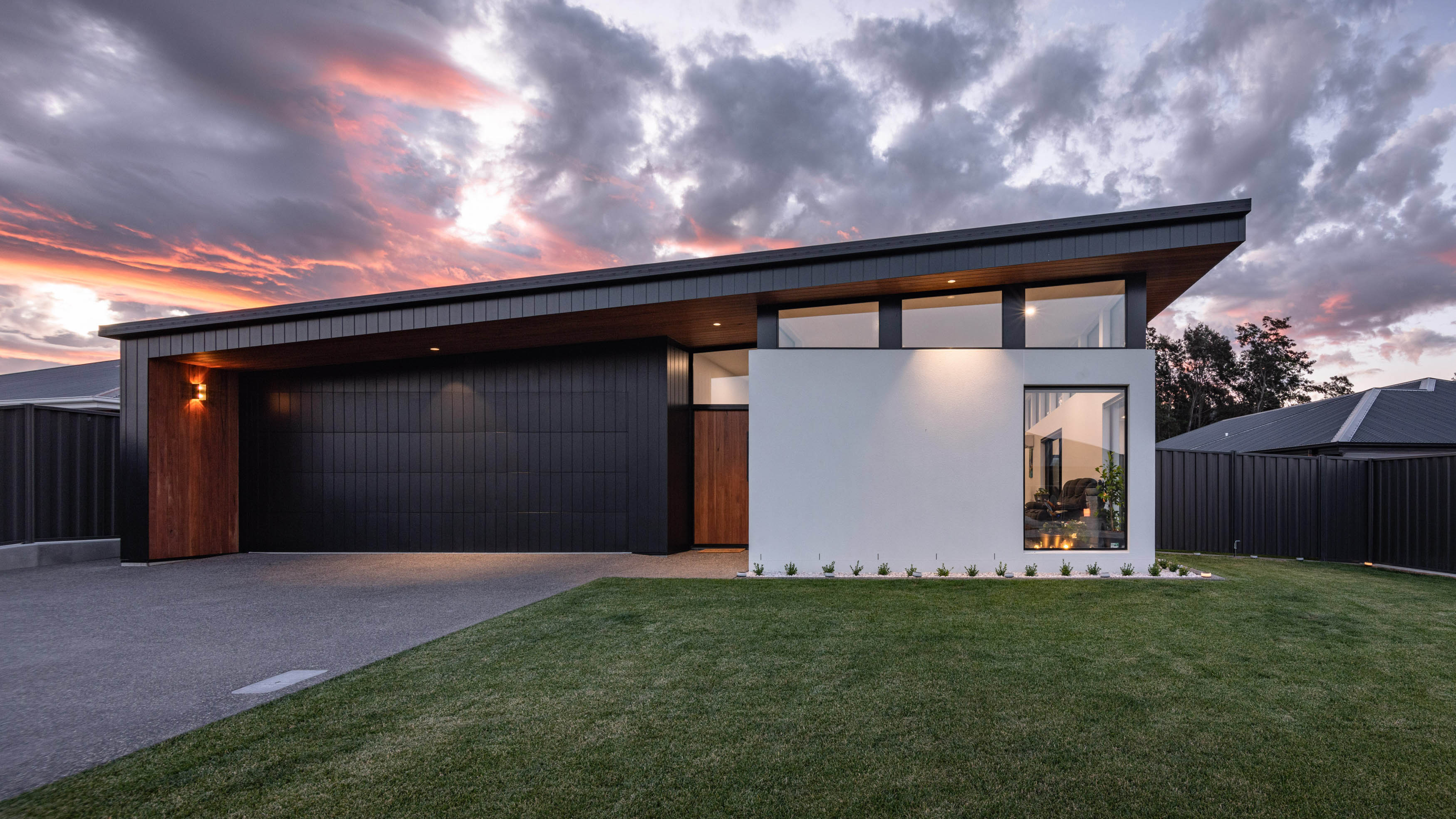 A Twilight sky with a white house and a wooden door.