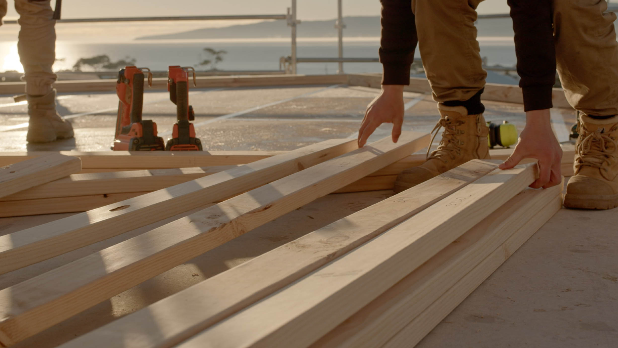House frame with a person standing on the top floor.